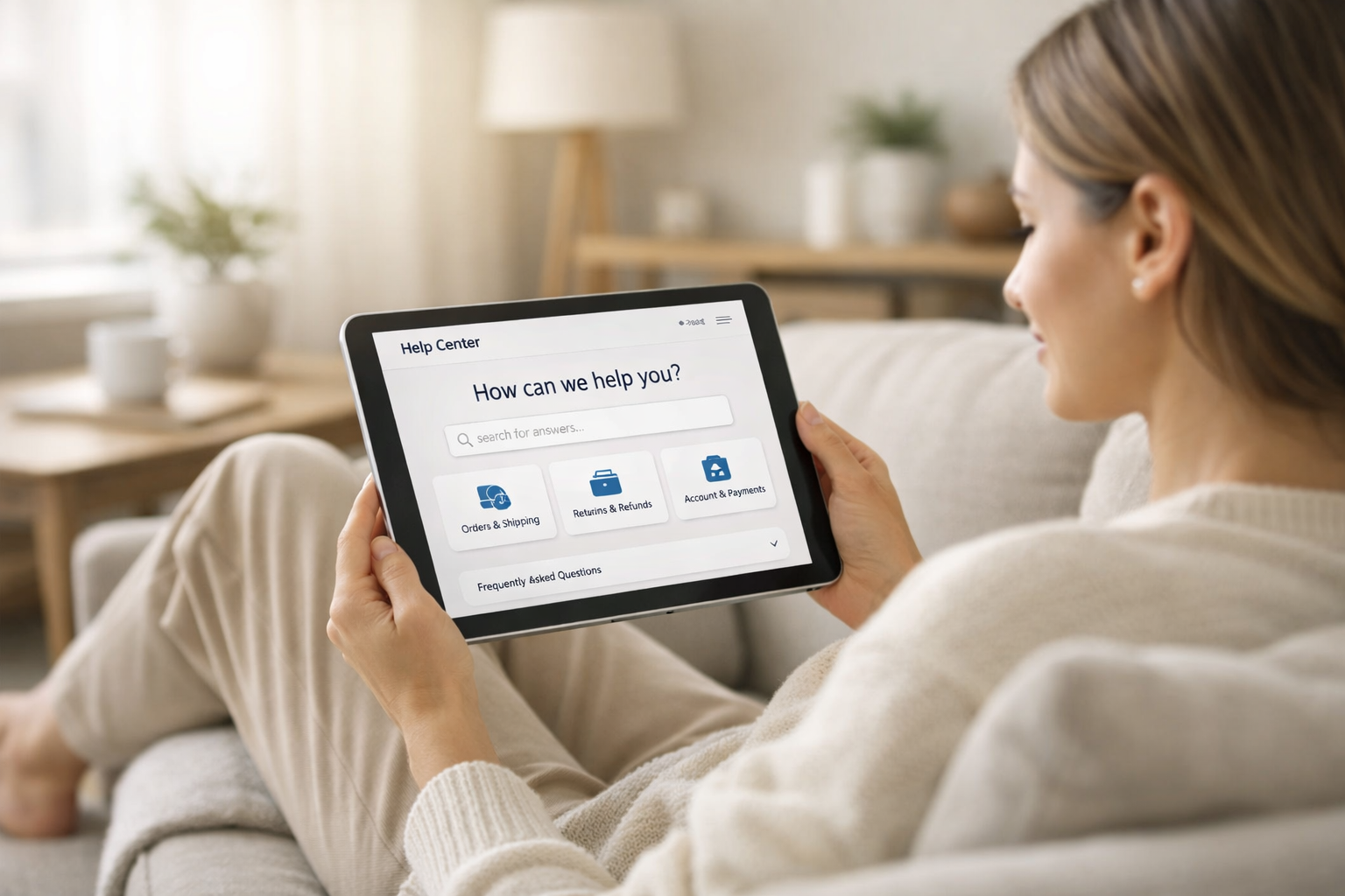 Minimal modern help and information concept, person sitting comfortably at home browsing answers on a tablet, soft natural daylight, cozy living room environment, clean neutral colours, calm and trustworthy atmosphere, ecommerce help center concept.