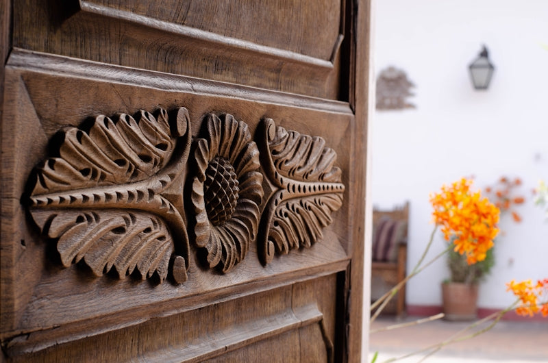 a close up of a wooden door with flowers in the background