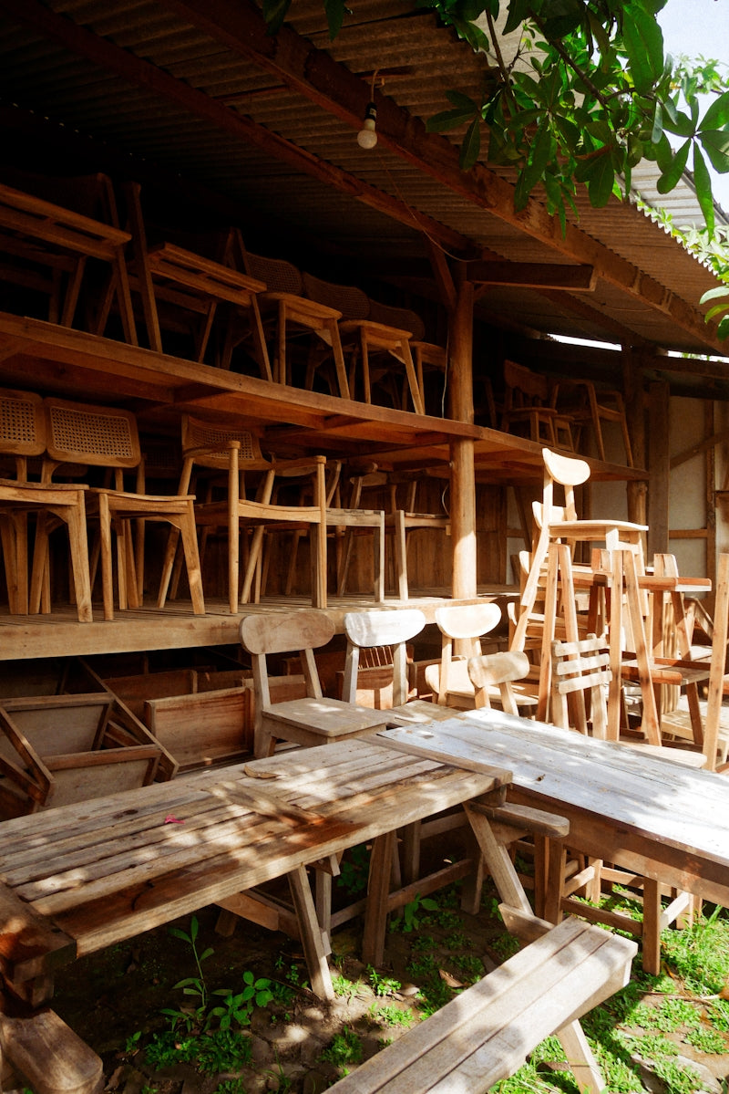 A row of wooden chairs sitting next to a wooden bench