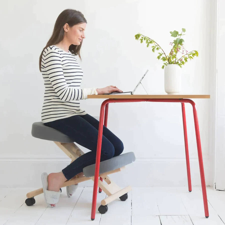 Kneeling chair with gray cushions.