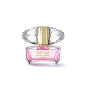 Versace Bright Crystal Eau de Toilette perfume bottle with pink liquid, a faceted clear cap, and a gold collar, centered on a white background.
