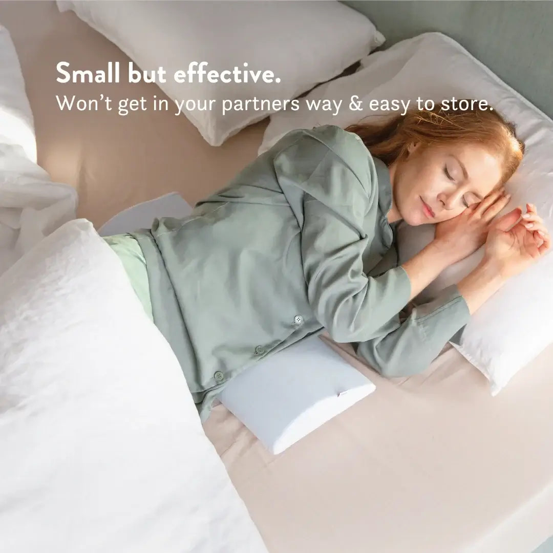Woman sleeping on a bed with a pillow, text 'Small but effective. Won't get in your partners way & easy to store.'