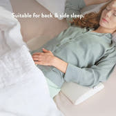 Woman lying on a bed with a pillow, suitable for back and side sleep.