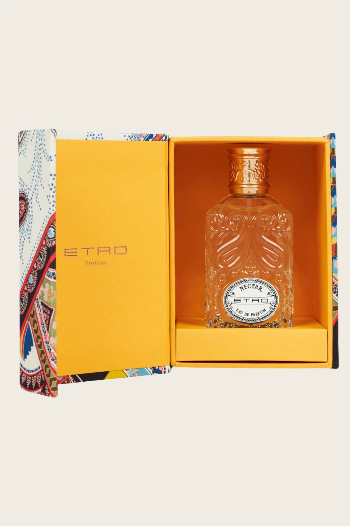 A clear glass perfume bottle with a gold cap, displayed inside an open bright yellow ETAO Parfum gift box with a multicolor paisley patterned outer sleeve, on a light beige background.